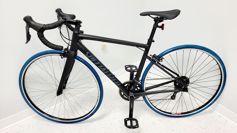 A black Specialized road bike with The SMART Tire Company's blue NiTinol+ tires made from a shape-memory alloy.