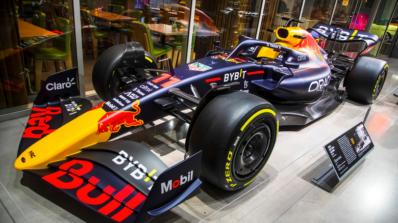 A Red Bull Racing Formula 1 car with Pirelli slicks at all four corners, sitting on a display in a museum.