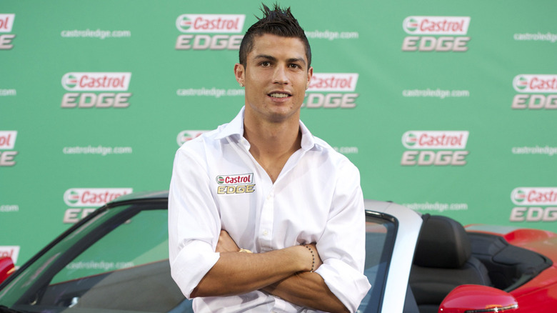 Cristiano Ronaldo stands in front of a car