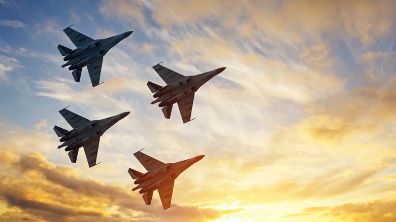 A squadron of four fighter jets flying in a diamond formation