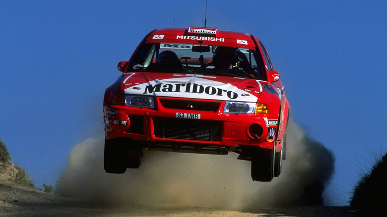 Tommi Mäkinen jumps a Mitsubishi Lancer Evo