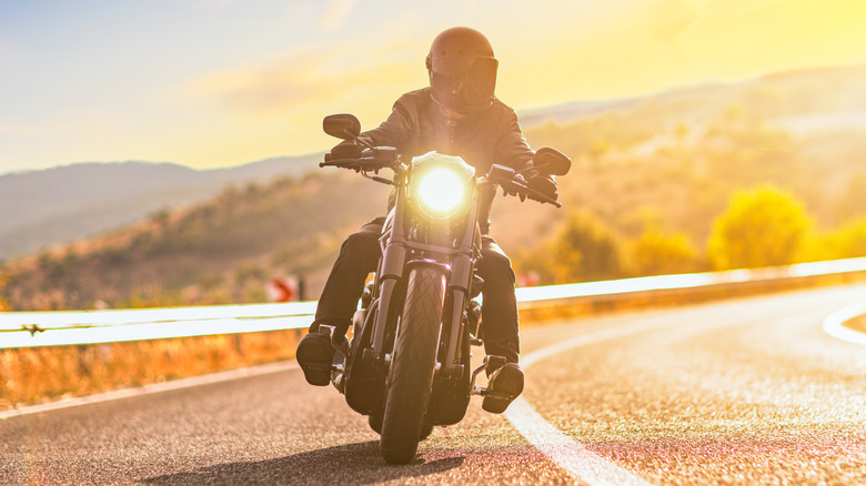 Man riding motorcycle at sunset