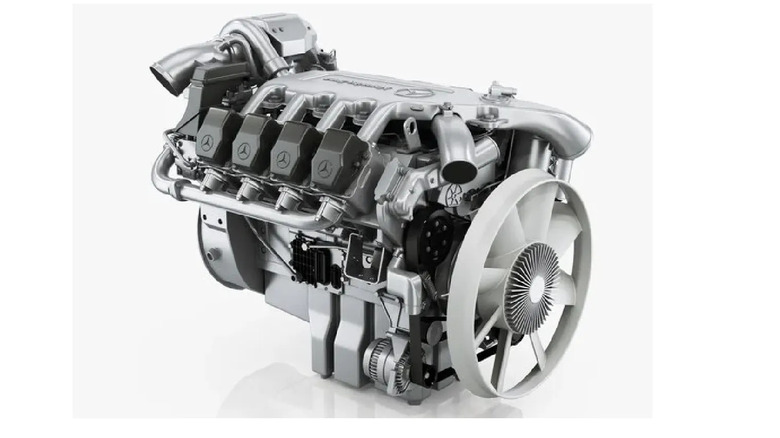 Mercedes-Benz OM 502 LA V8 diesel engine with silver metallic finish, large front-mounted cooling fan, and distinctive cylinder head covers featuring the Mercedes logo.