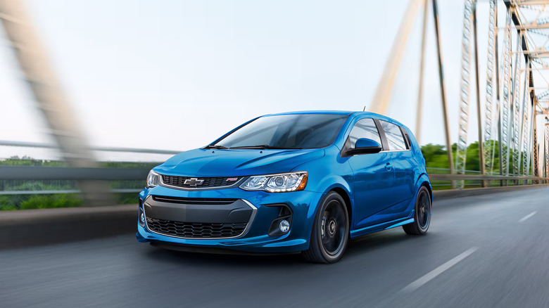 Blue Chevrolet Sonic driving across a bridge