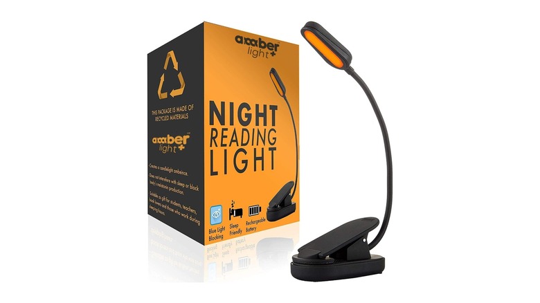 Amber colored light attached to a black neck and clip next to product packaging