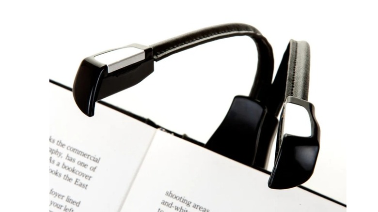 Black device with two lights attached to a book