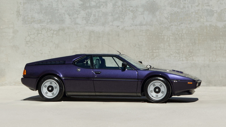 BMW M1 supercar side view in front of a grey wall