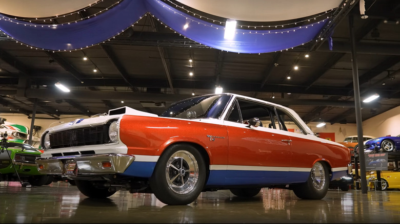 An AMC Hurst SC Rambler in red white and blue livery being displayed indoors at an auto museum