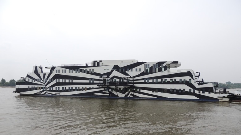 Accommodations barge Sans Vitesse with striking black and white dazzle camouflage seen docked
