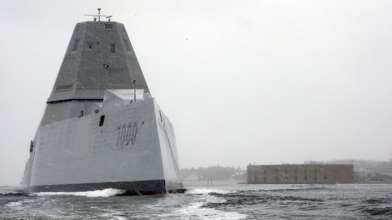 USS Zumwalt ship seen from in front near shore on a stormy winter day