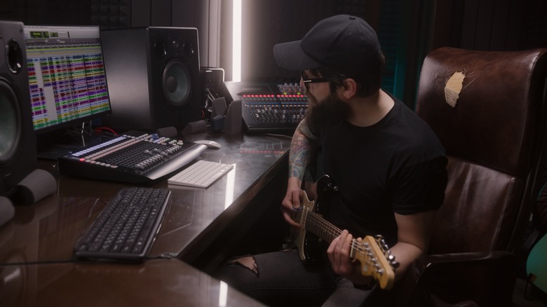 man digitally recording his guitar