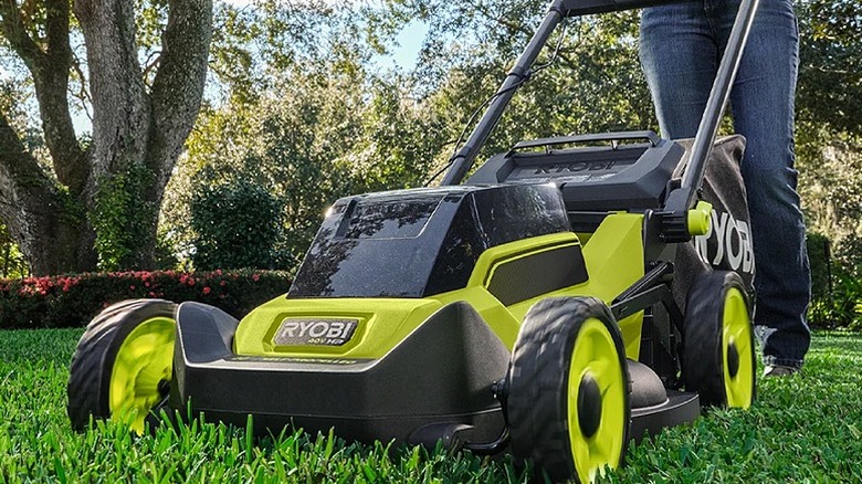 Man using a push lawn mower for lawn maintenance.