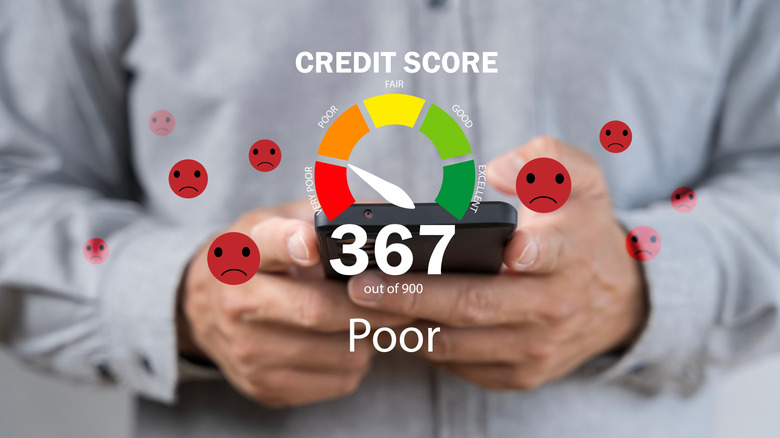 person holding smartphone with bad credit score showing