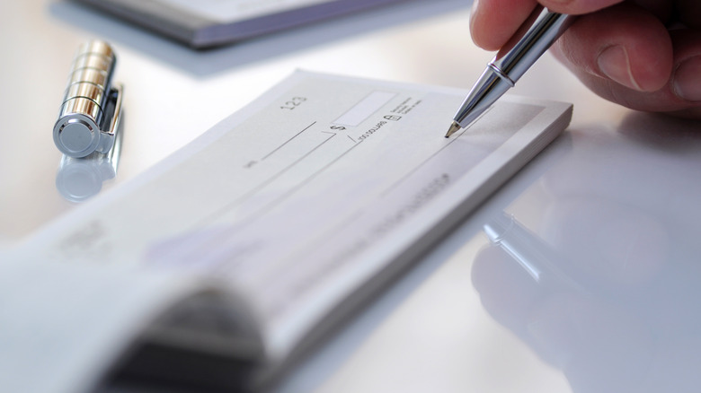 closeup of someone writing a personal check
