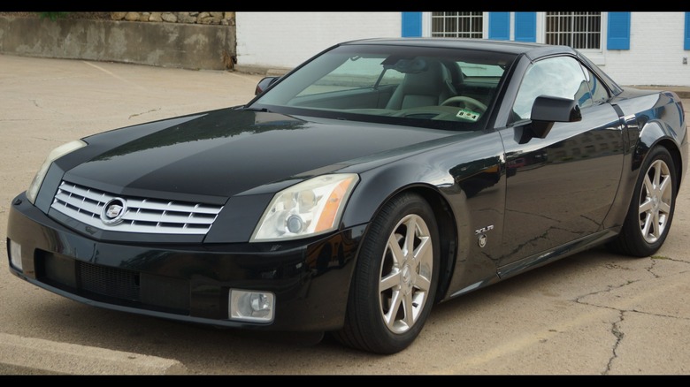 Black Cadillac XLR roadster seen from front left in a parking lot