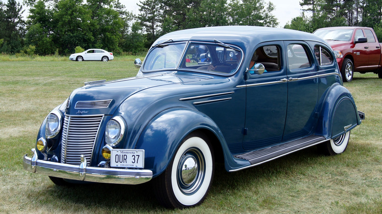 Blue 1937 Chrysler Airflow sedan seen from left front parked on grass