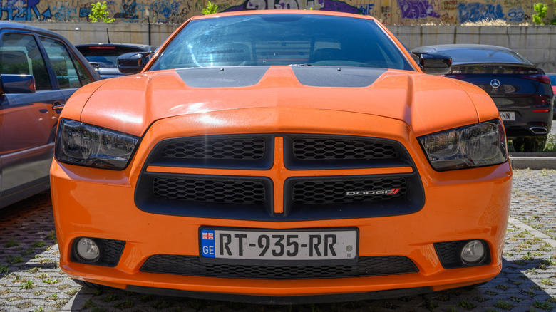 Front end of an orange Dodge Charger in parking lot