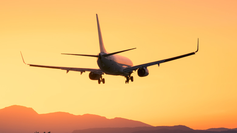 A passenger aircraft flying with an amazing backdrop of a sunset