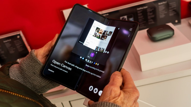 A person holding a OnePlus Open smartphone