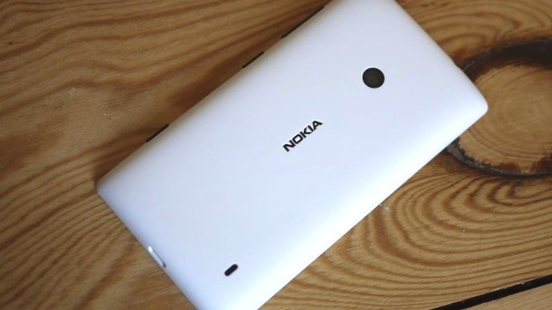 White Nokia Lumia 520 face-down on a wood surface