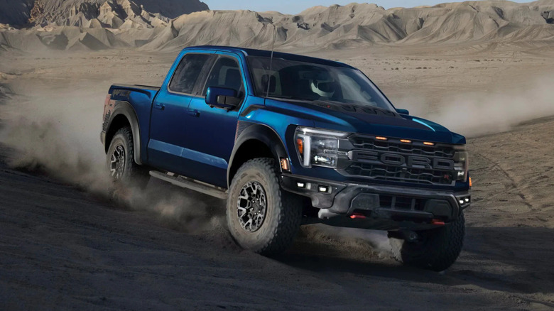 Blue Ford F-150 Raptor R cornering on a sand dune.