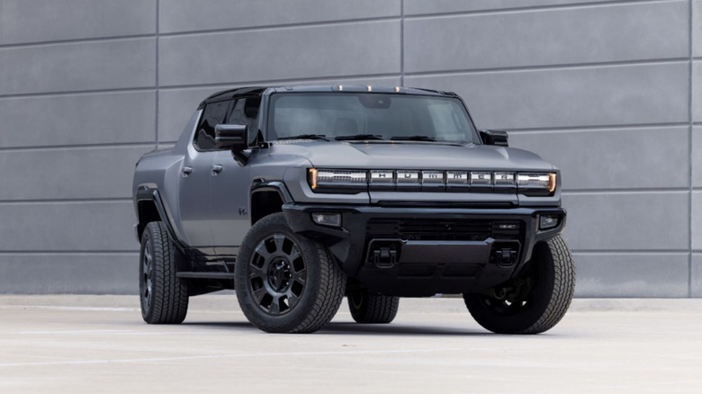 Gray GMC Hummer EV parked in front of a gray wall.