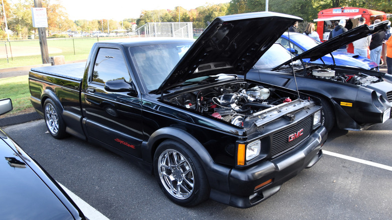 GMC Syclone on display with hood open at a car show.