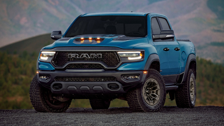 Blue 2024 Ram 1500 TRX parked on gravel.