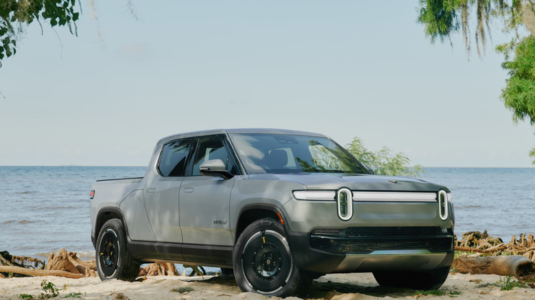 Gray Rivian R1T parked on a beach.