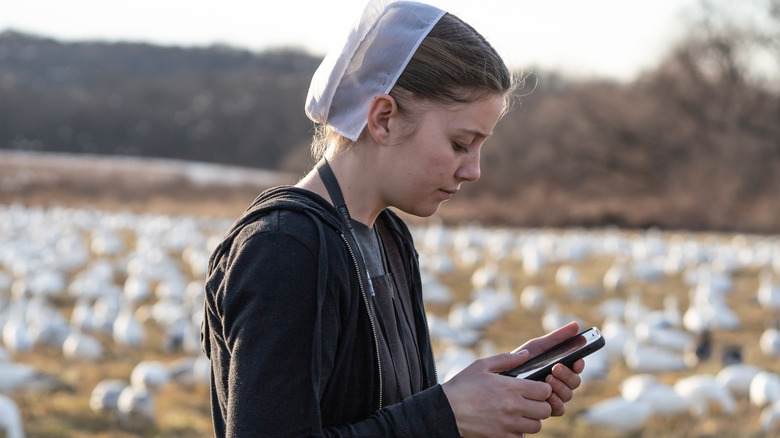 Amish womanin field on cell phone