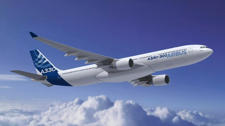 Airbus A330 Regional jet flying above the clouds against a blue sky, showcasing modern twin-engine design and Airbus branding.