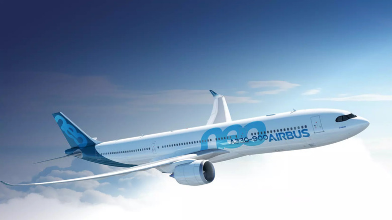 Airbus A330-900neo aircraft soaring above the clouds, featuring advanced winglets and modern fuel-efficient design.