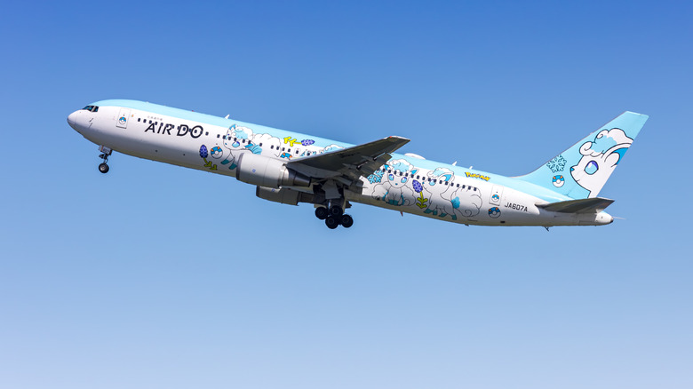 A boeing 767-300ER taking off from Tokyo, right to left, nose up in the air and Air Do livery visible.