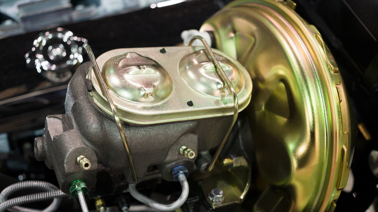 Close-up of a car's brake master cylinder and brake booster.