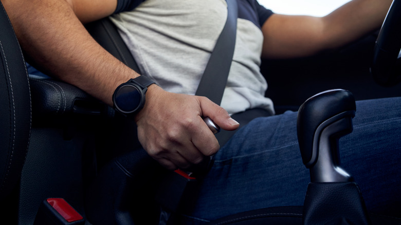 Driver pulling the handbrake lever inside a car.