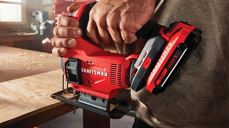 Cutting wooden board with Craftsman jigsaw.