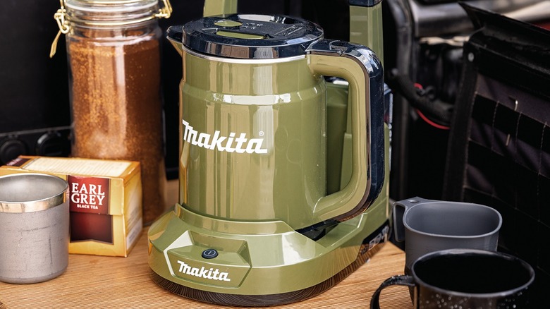 Makita Outdoor Adventure 36V (18V X2) LXT Hot Water Kettle on a table surrounded by mugs and containers