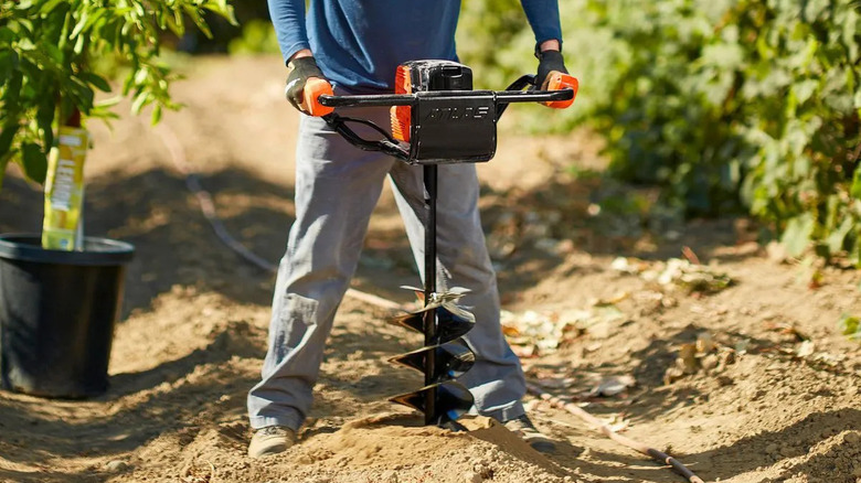Landscaper using an Atlas 80V auger