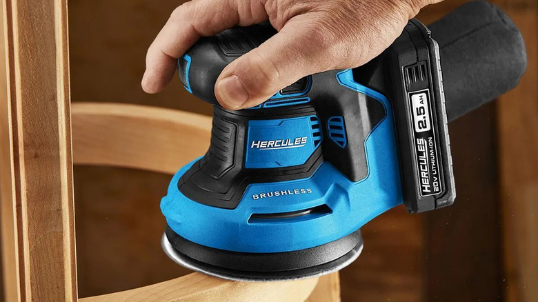 Woodworker using a Hercules 20V random orbit sander