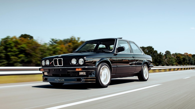 A BMW E30 driving at speed