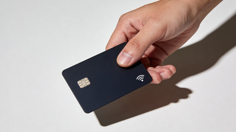 A hand holding a credit card