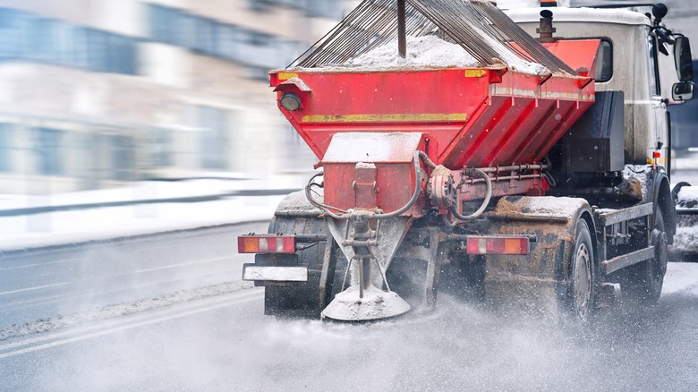 Maintenance truck dispersing salt on an icy road