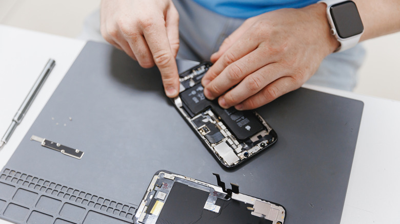 A person replacing the battery on an iPhone