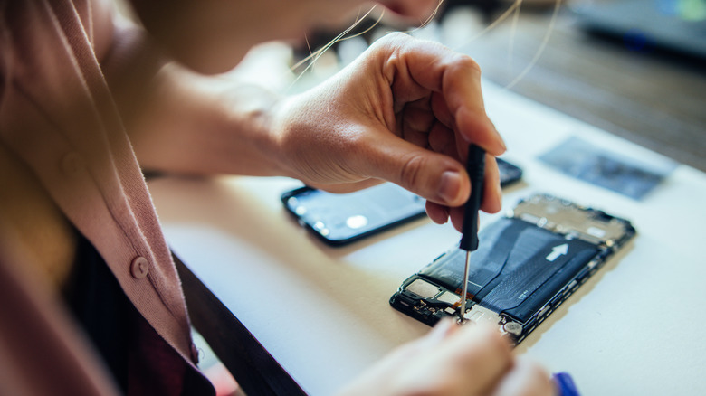 A technician repairing an iPhone