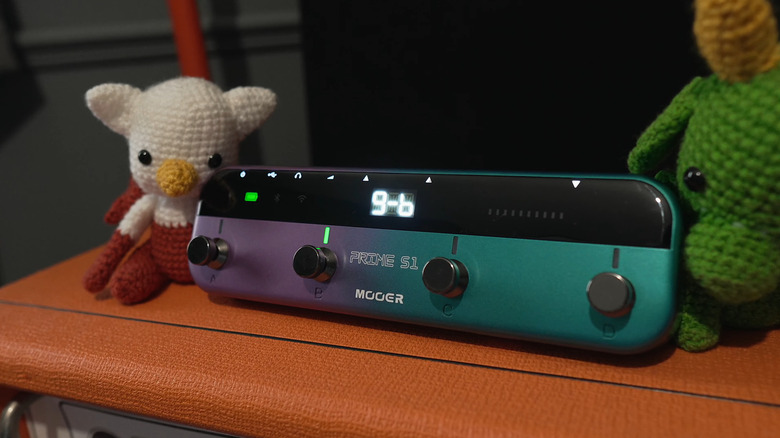 A MOOER S1 Multi-Effects Processor on a shelf, flanked by two stuffed animals