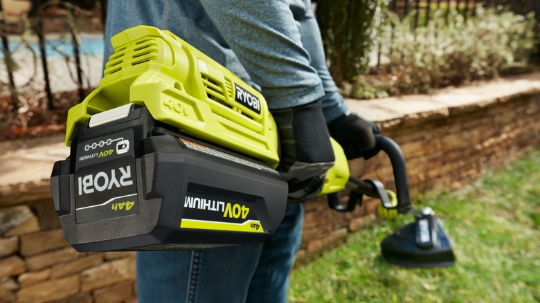 Man using Ryobi string trimmer