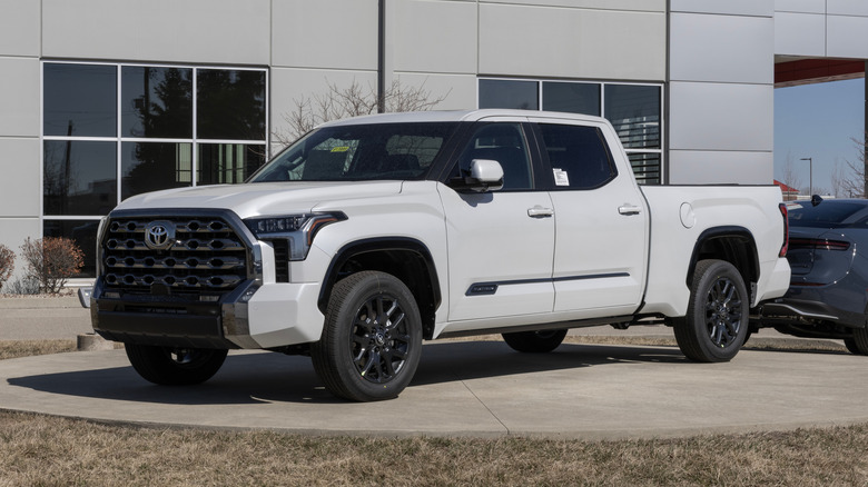 A white 2025 Toyota Tundra on display in front of a Toyota showroom