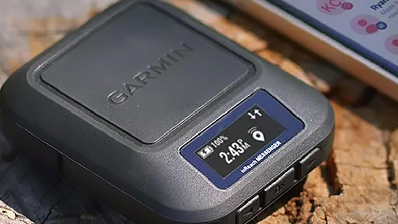 The Garmin inReach Messenger satellite communicator next to a phone.