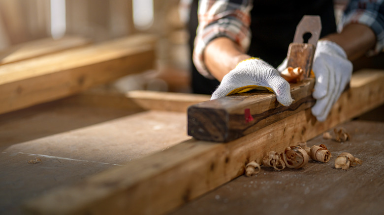 woodworkerusing a wooden plane