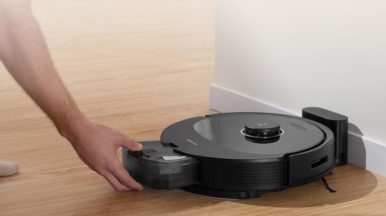man taking out roborock compartment